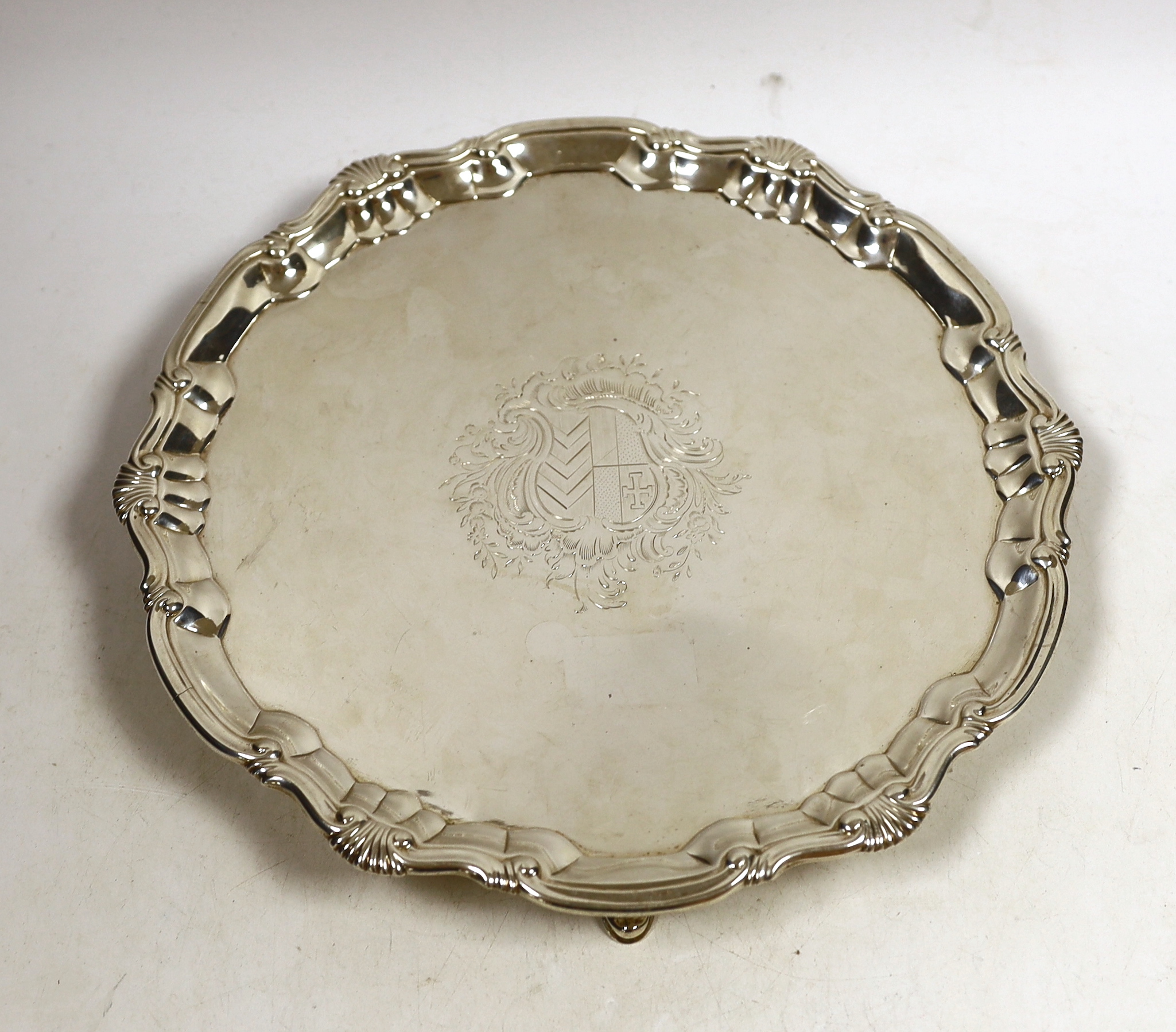 A George II silver salver, of shaped circular form, with shell and scroll border and engraved armorial, on three hoof feet, William Peaston, London, 1747, diameter 29.4cm, 27.2oz.